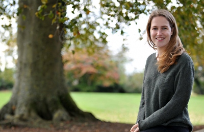 Student standing by tree