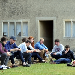 Students sitting on wall and lawn talking