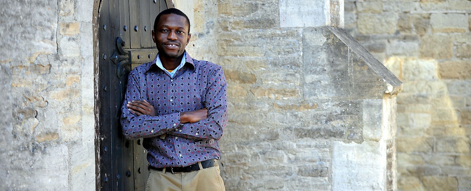 Student in front of stone wall
