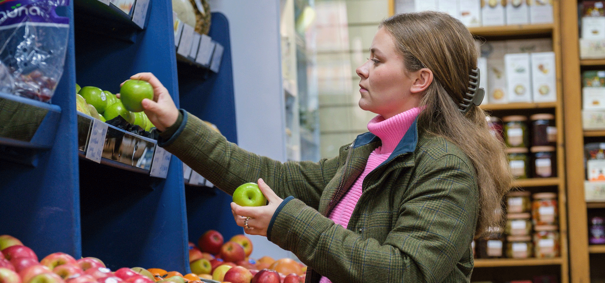 Girl choosing apples from shop