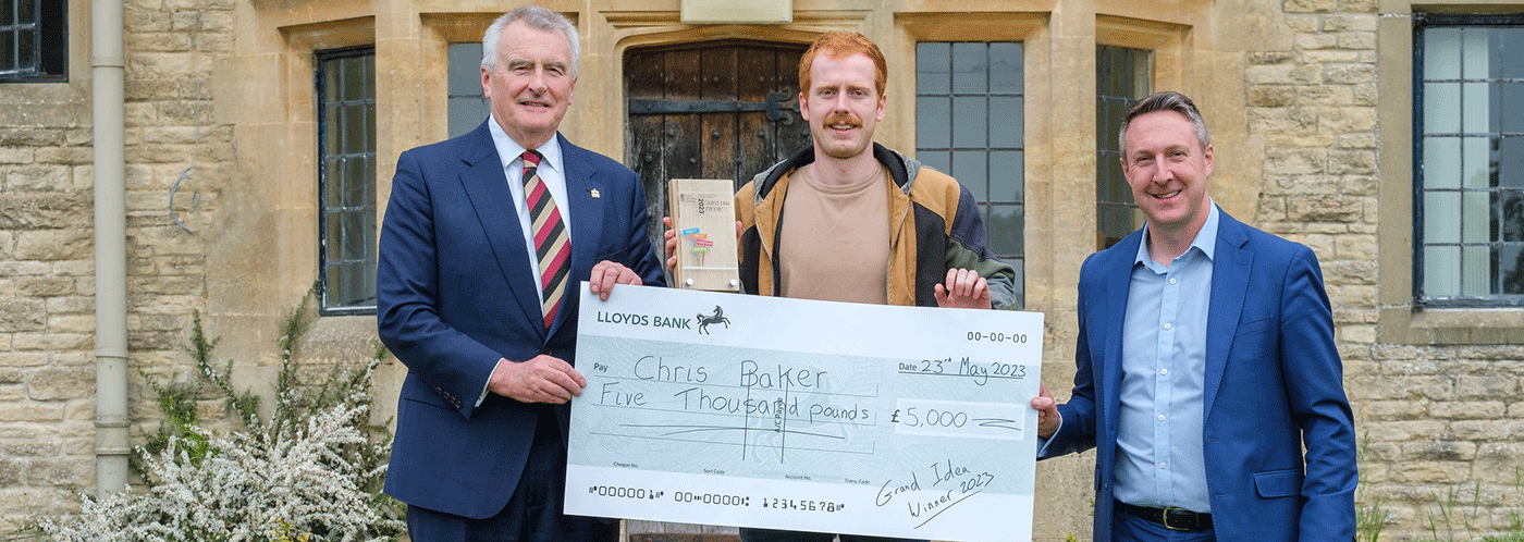 grand idea winner and vice chancellor holding cheque
