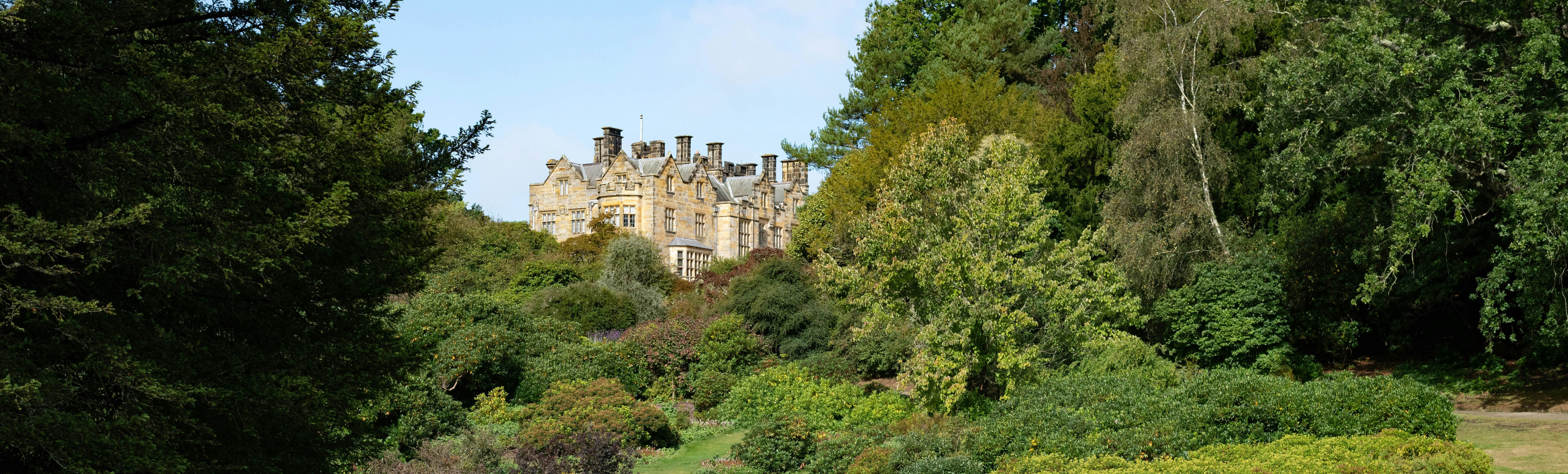 large country house surrounded by garden and trees