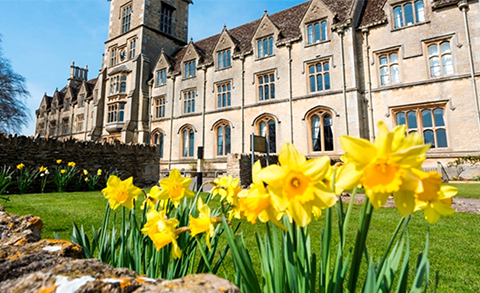 The front of the Royal Agricultural University with daffodils in foreground