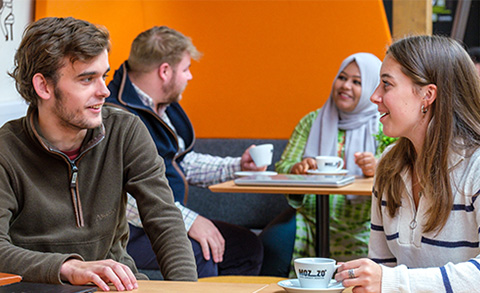 Students sitting in a cafe chatting
