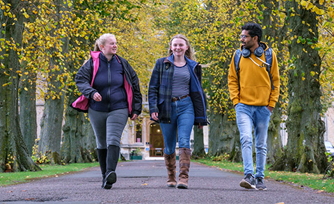 Three students walking down the driveway