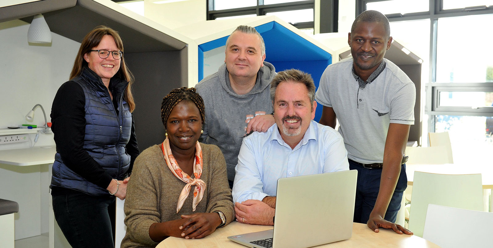 five postgraduate students smiling