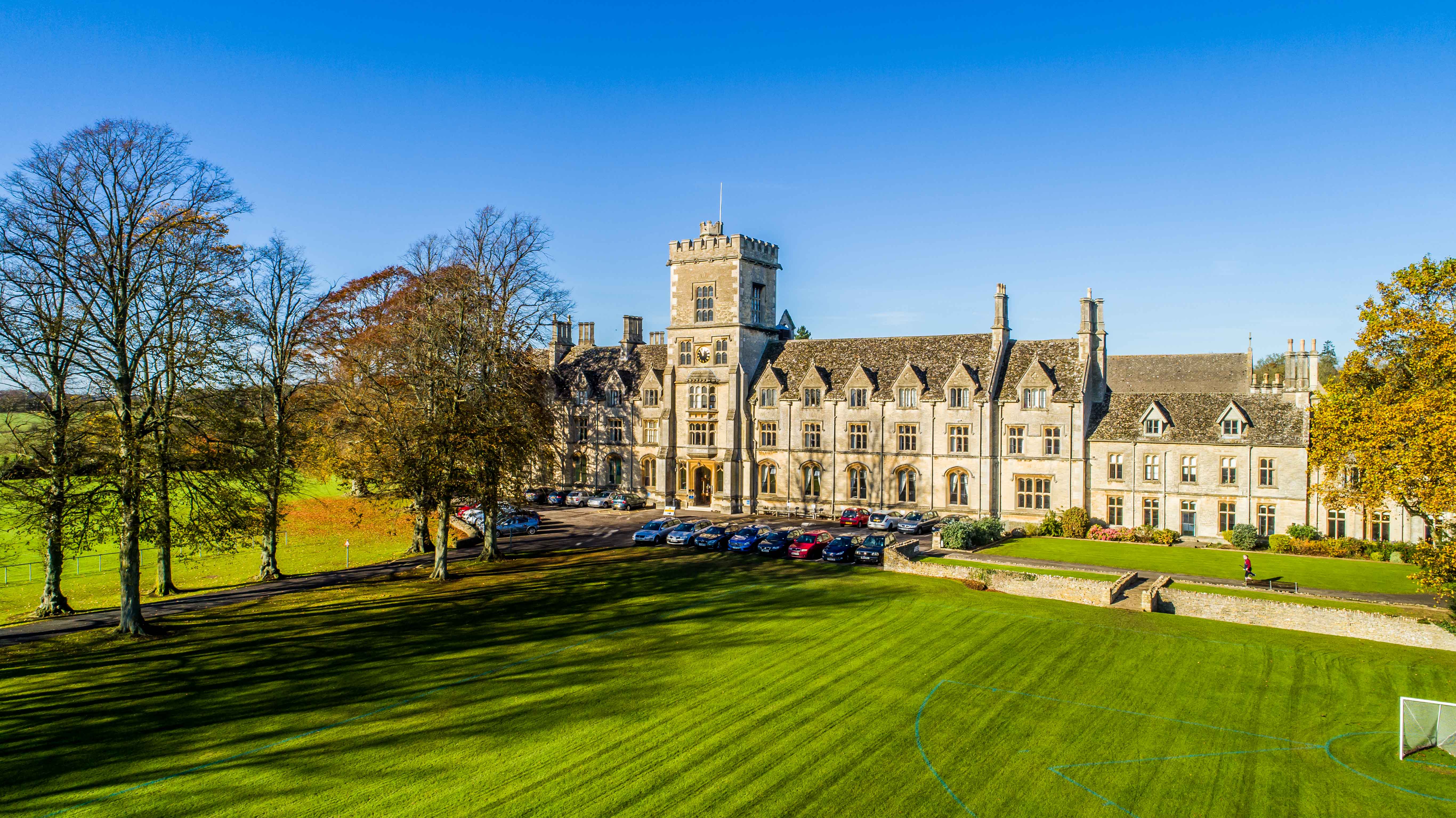 A photograph of the Royal Agricultural University main building on a sunny day with a blue sky. 