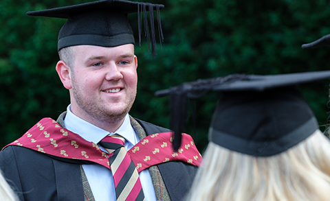 Graduating student in robes and wearing RAU tie