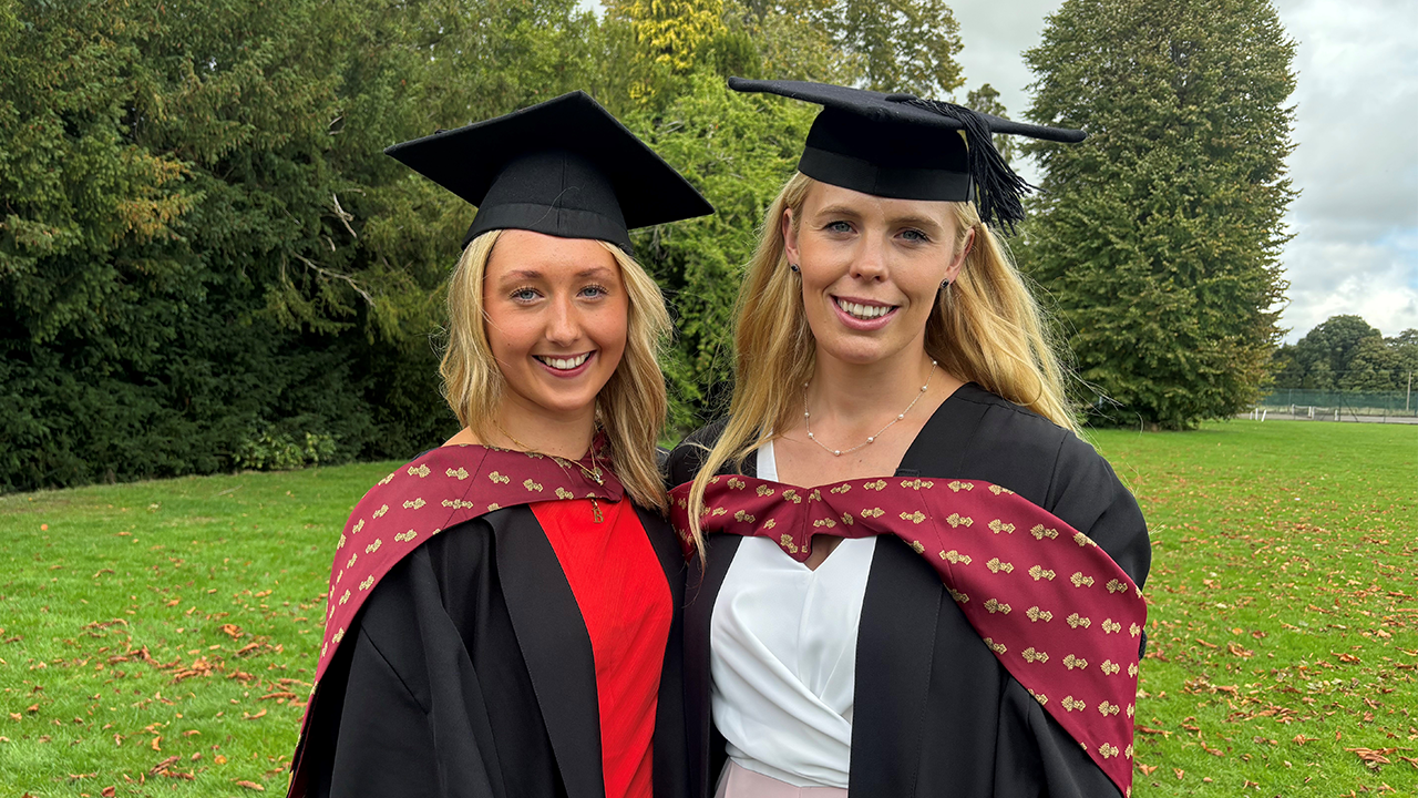 Two graduating students in robes