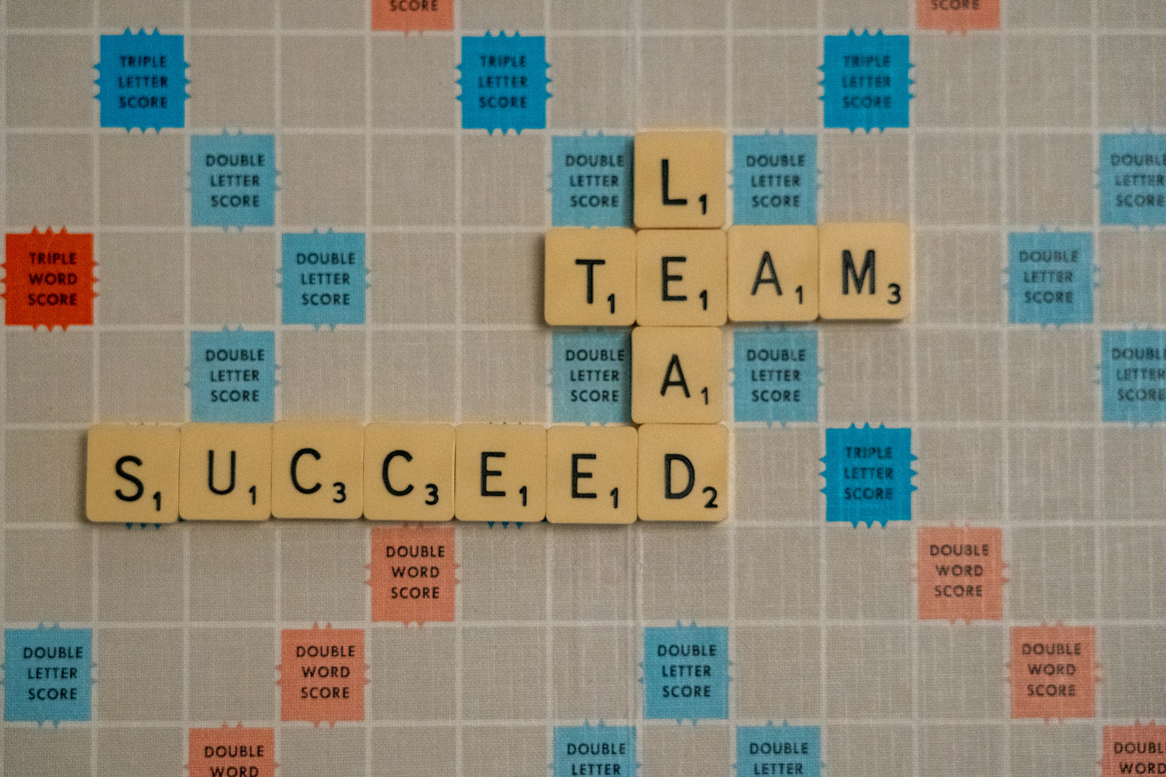 Scrabbles piece spelling 'succeed', 'team' and 'lead'