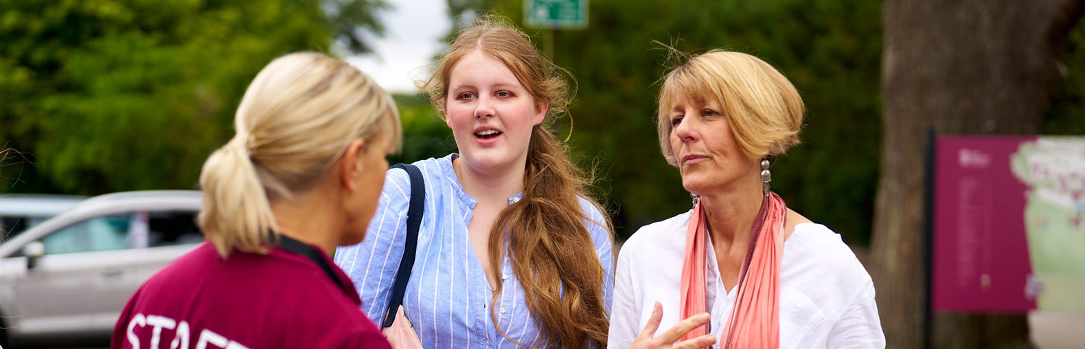 staff member talking to mother and daughter