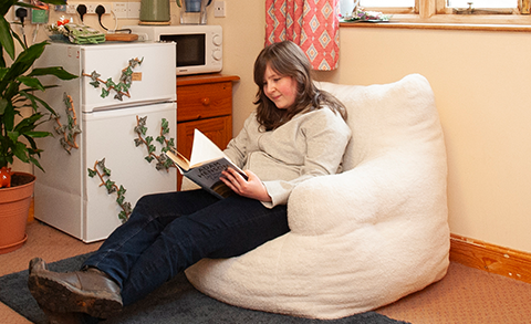Student reading a book in their room