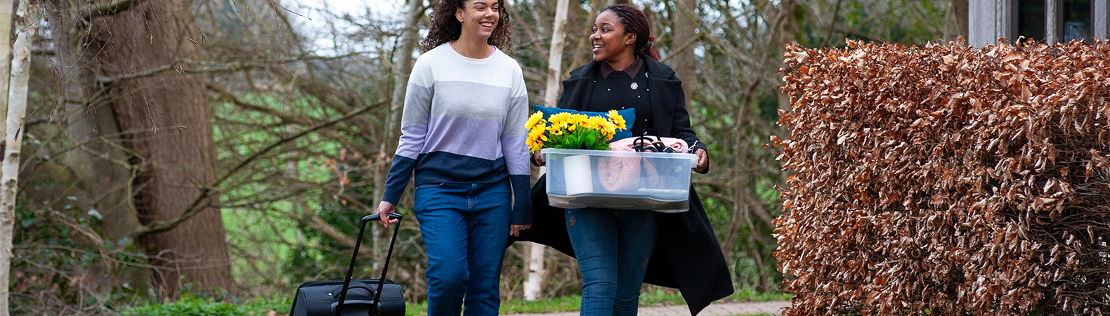 Two students carrying belongings