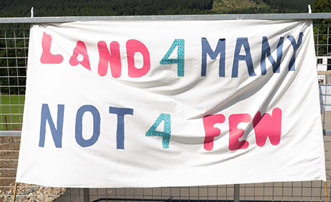 A banner with text "land 4 many not 4 few"