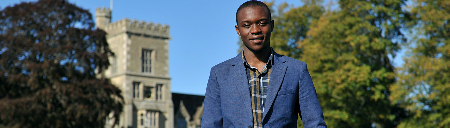 A student stood in front of the Royal Agricultural University