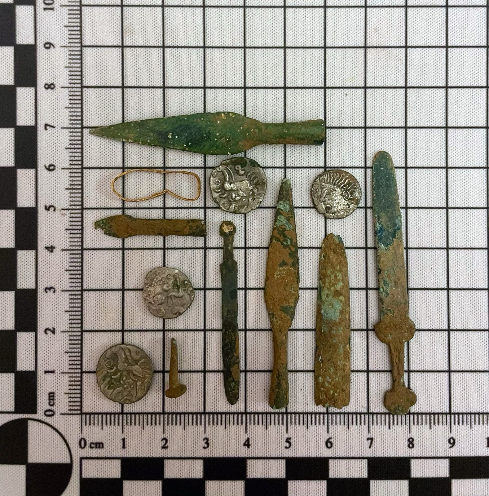 Selection of coins and miniature weapons found during archaeological dig