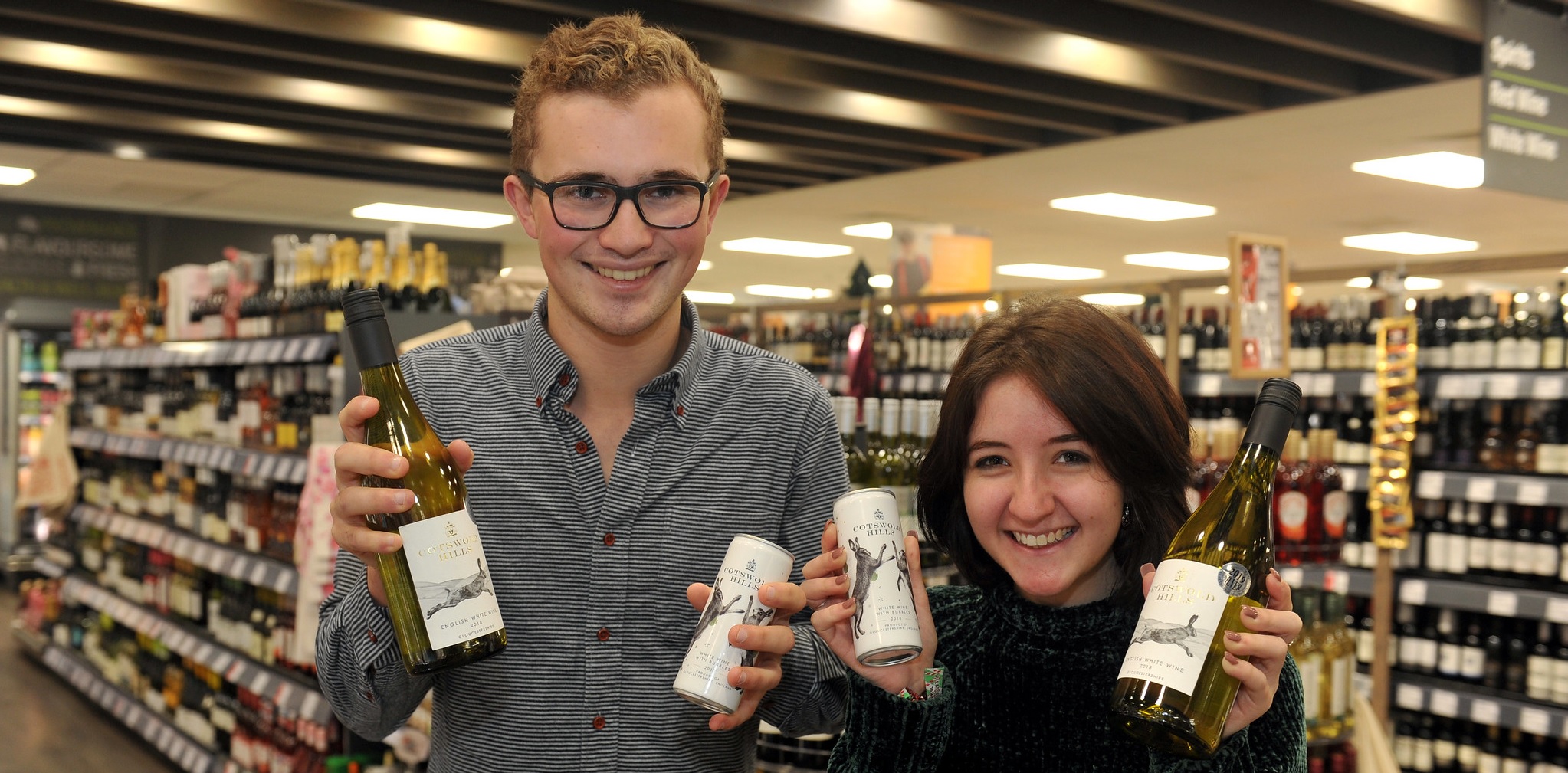 Students holding Cotswold Hills wine bottles