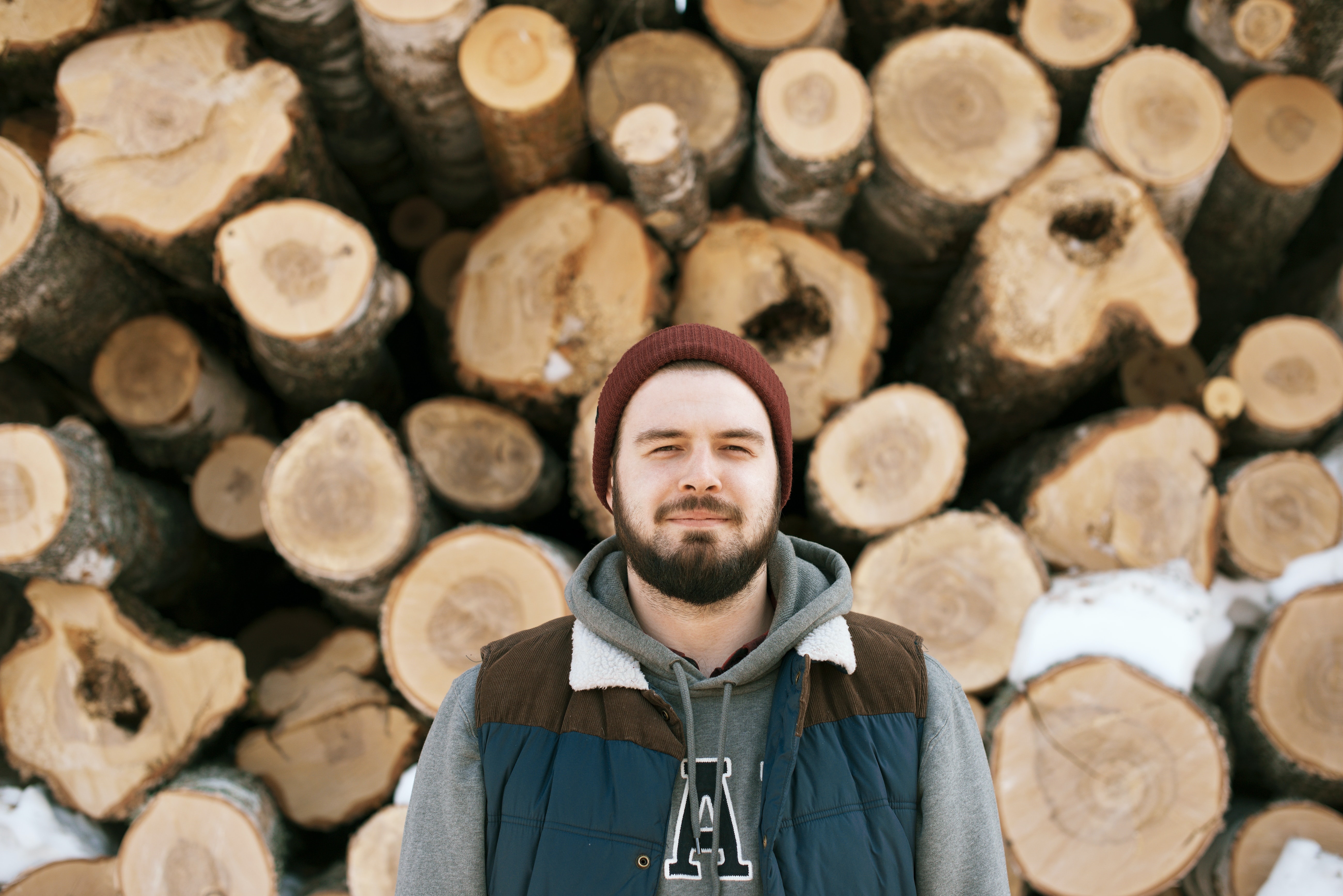 Man in from of logs