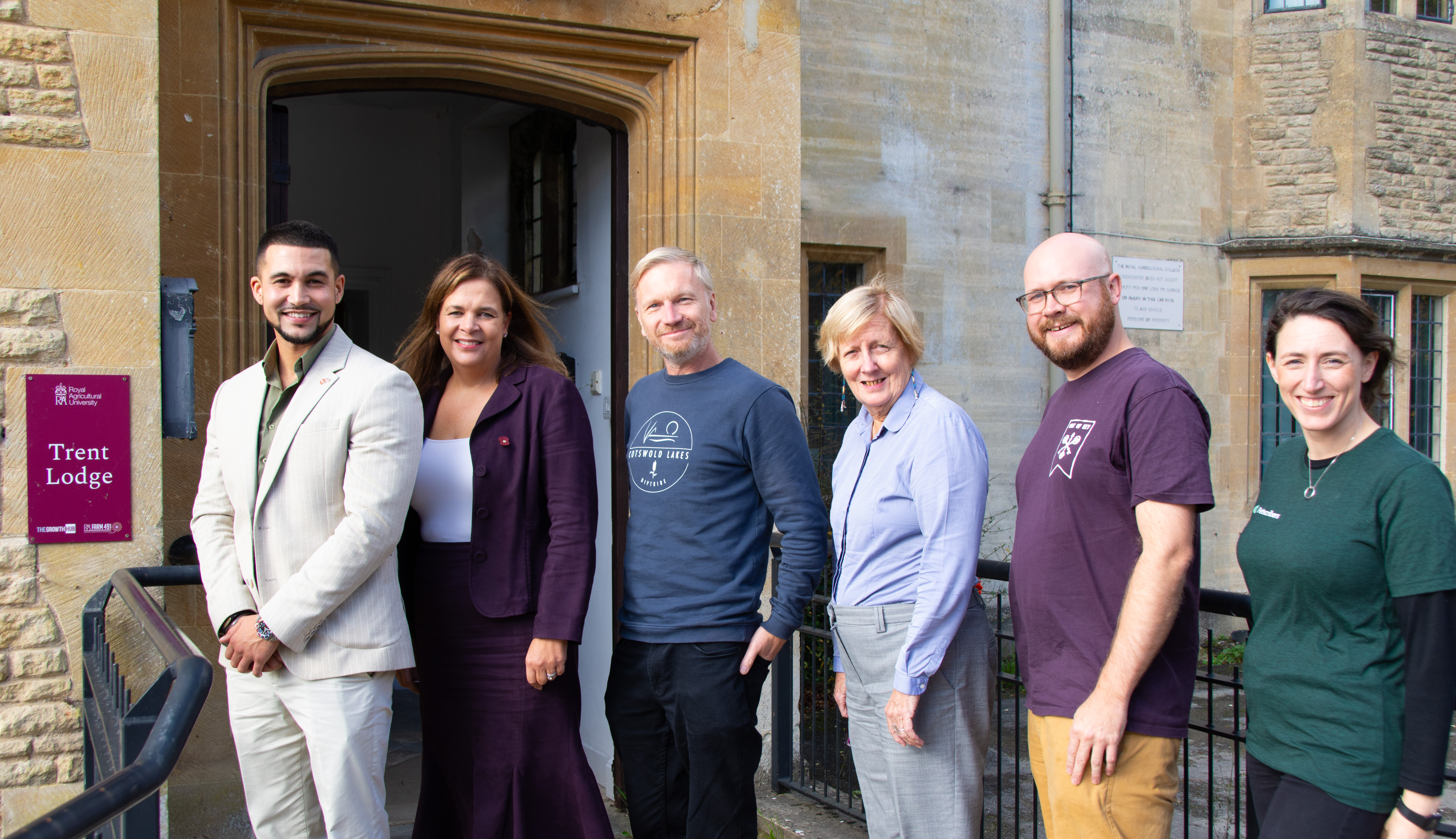 six people standing in front of a building