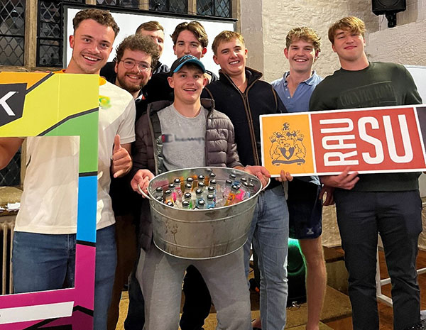 Group of male students holding RAUSU sign