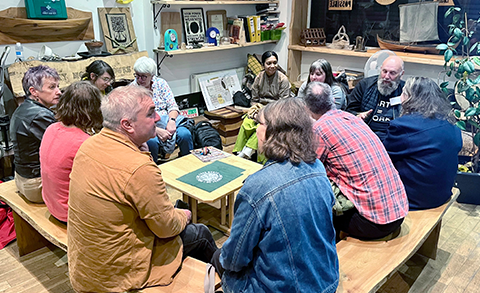 A group of people sat around a table, attending a workshop meeting