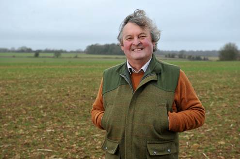 Man standing in front of field with hands in gilet pockets