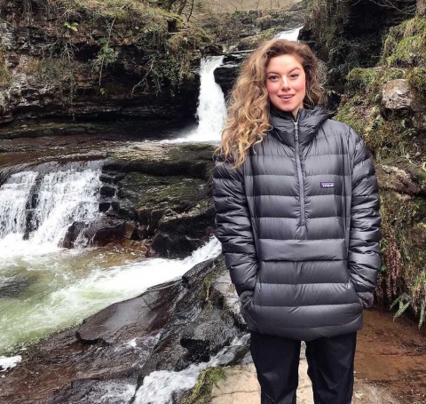 Shaelyn Bertrand standing next to a waterfall