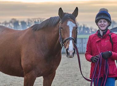 Student holding a horse
