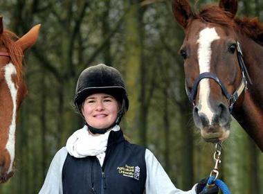 Student holding two horses