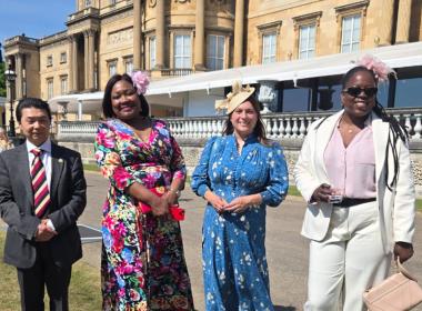 Four members of staff at a garden party in grounds of Buckingham Palace