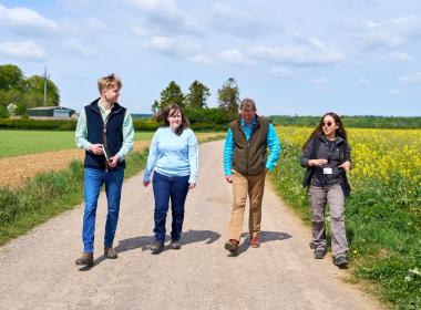 group of 4 people chatting walking down a country lane