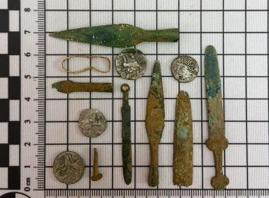 Selection of coins and miniature weapons found during archaeological dig
